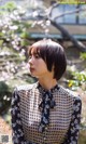 A woman standing in front of a flowering tree.