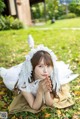 A woman in a white dress laying on the grass.