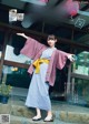 A woman in a blue and white striped dress and a pink kimono.