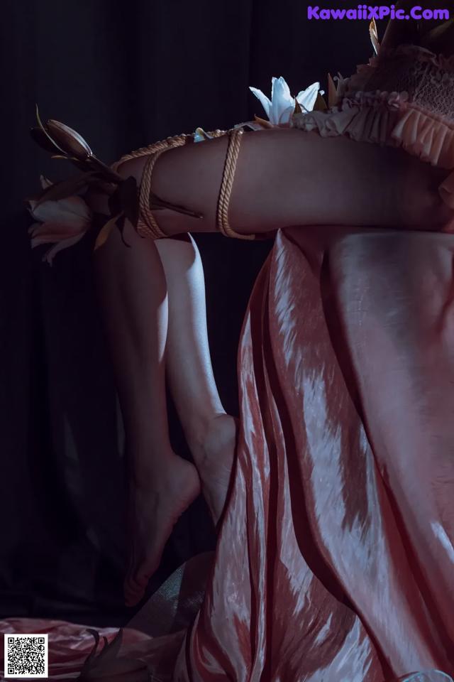 A woman in a pink dress with a flower in her hand.